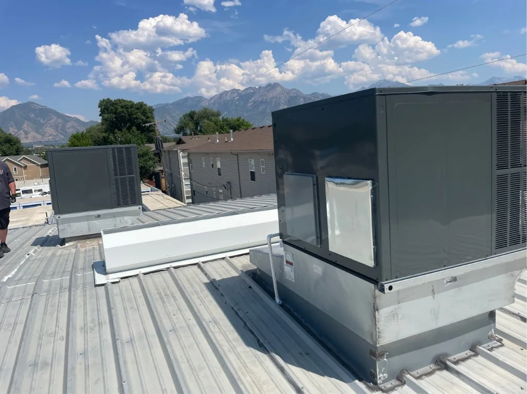 S.O.S technicians' commercial RTU install with Wasatch Mountains in the background — Salt Lake City area