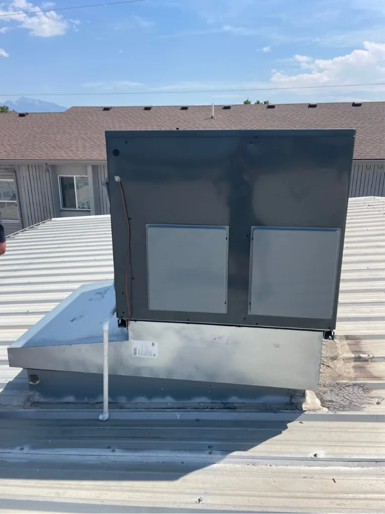 Rear view of a rooftop package unit installed on a curb-mounted commercial roof